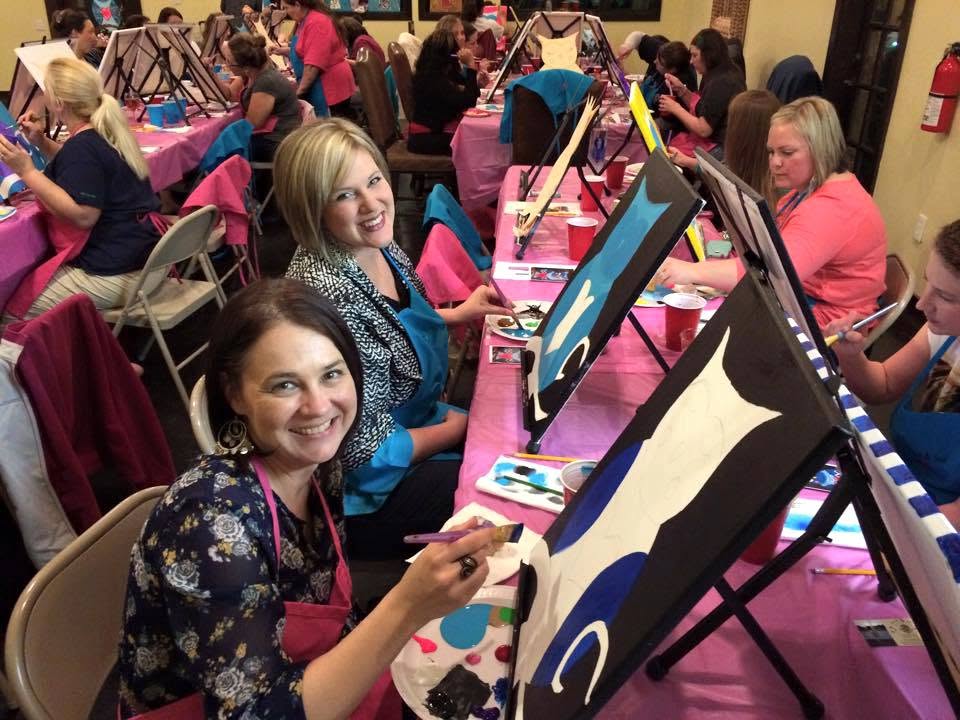 Guests painting together at a lively group paint party